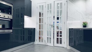 A modern kitchen with dark cabinetry, a built-in oven, and a marble backsplash. - Memory of Lisbon (Lisbon)