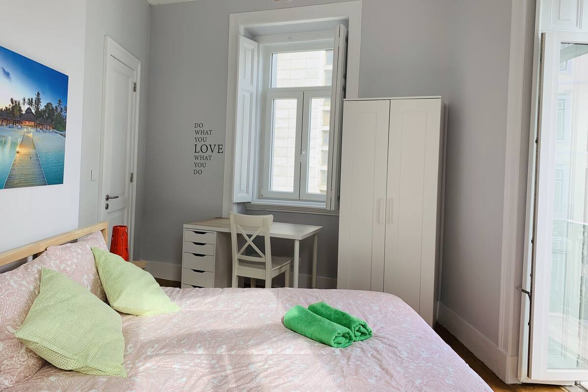 A bedroom with a bed, a desk, a wardrobe, a window, and a motivational quote on the wall.