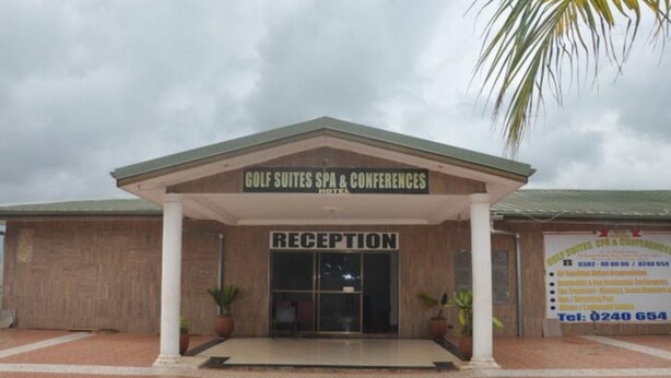Un bâtiment comprenant un espace d’accueil et une enseigne indiquant la présence d’un spa, de suites pour golfeurs et de salles de conférence.