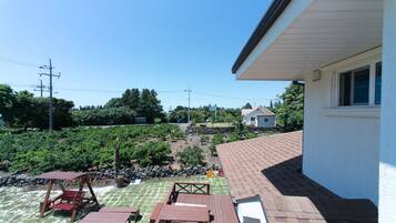 A patio area with a wooden deck, tables, and a swing set.