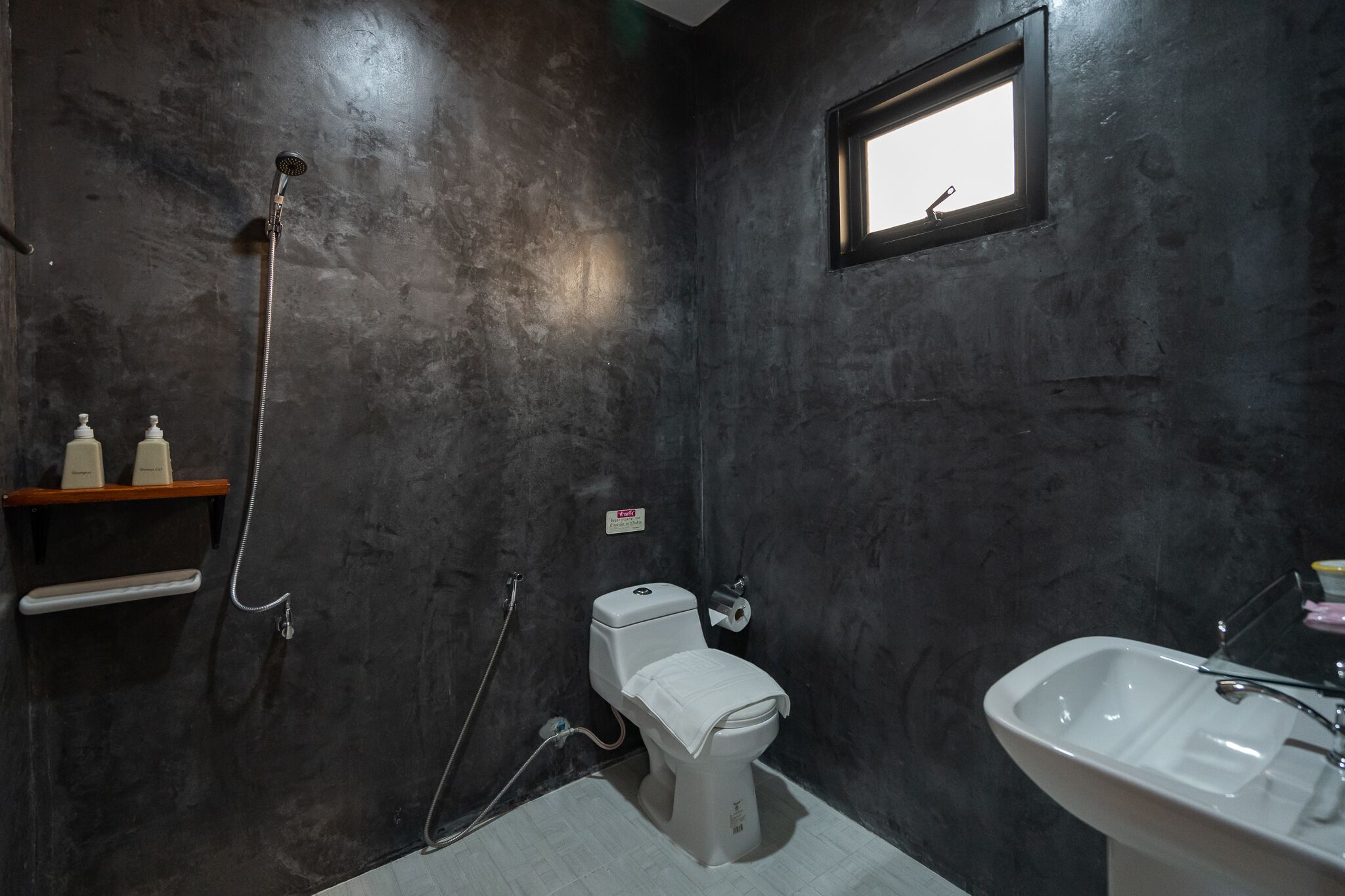 Un baño con inodoro, ducha y lavamanos.