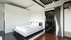 Een modern hotelkamer met een minimalistisch design, met een groot bed, een glazen schuifdeur naar de douche en een opgeruimde, rustige ruimte.