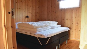 A single bed with a dark mattress and white bedding in a room with wooden walls and a window. - Gorgeous home in Hol i Tjeldsund (Hol i Tjeldsund)