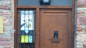 Een houten deur met een ruit en een bordje met de tekst 'Vilapart'.