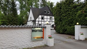 Un edificio tradicional de entramado de madera con un letrero que dice "HOTEL PENSION".