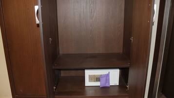 Une armoire en bois avec une étagère intégrée et un appareil électronique blanc posé sur l’étagère inférieure.