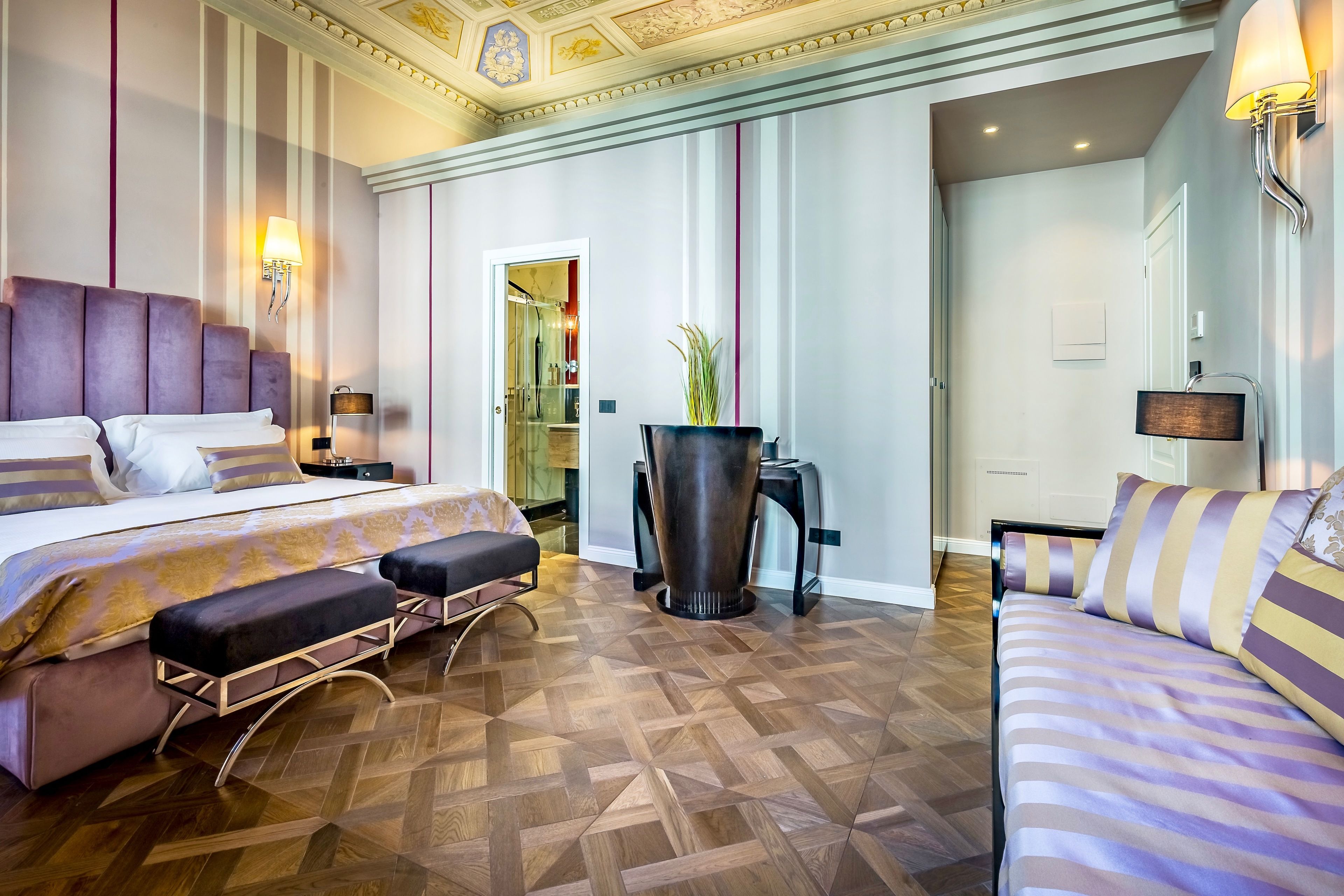 A hotel room with a large bed, a smaller bed, a desk, and a chair.