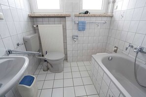 A bathroom with a toilet, bidet, and bathtub. - Apartment 4 - Panorama of the house (Sankt Andreasberg)
