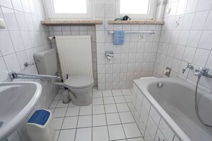 Un baño con inodoro, bidé y bañera.