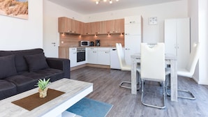 A modern apartment with a living area, kitchenette, and dining space. - Apartment Hanseatic city Zwolle (Wittmund)