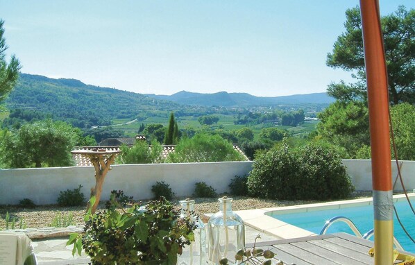 Vista da piscina com paisagem montanhosa ao fundo.