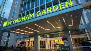 The Wyndham Garden hotel entrance with a modern design, large glass windows, and a prominent illuminated sign. - Wyndham Garden Hanoi (Hanoi)