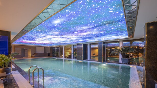 An indoor swimming pool with a ceiling displaying a starry sky. - Wyndham Garden Hanoi (Hanoi)