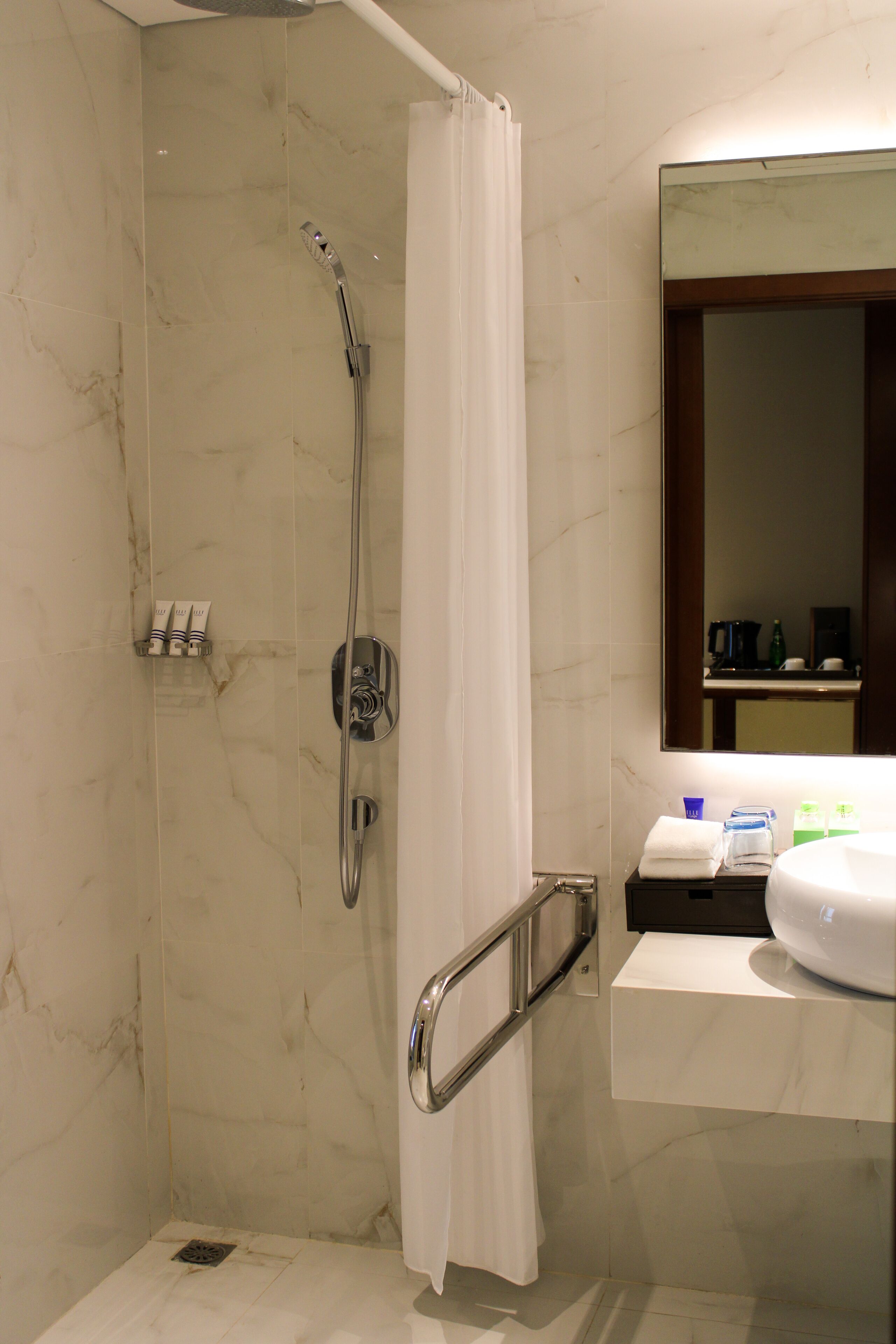 A bathroom with a shower, a toilet, and a sink.