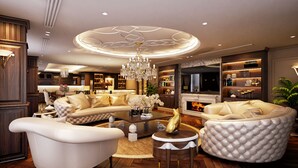 A luxurious living room with a large sofa, a coffee table, and a fireplace. - Wyndham Garden Hanoi (Hanoi)