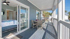 A covered porch with a bed, a table, and chairs. - COZY & CLOSE TO BEACH, VERY CLEAN, PRIVATE POOL, PET FRIEND FEE, LSV DISCOUNT (Destin)