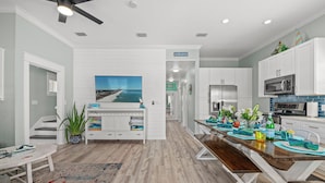 A modern kitchen with white cabinets, a dining area with a wooden table, and a view of the ocean through a large window. - COZY & CLOSE TO BEACH, VERY CLEAN, PRIVATE POOL, PET FRIEND FEE, LSV DISCOUNT (Destin)