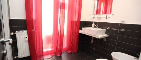 A bathroom with a white sink, a mirror, and a toilet.