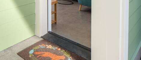 Una puerta que da a un cuarto con una zona de cocina visible.
