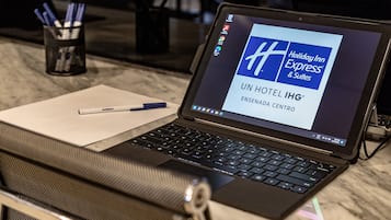 A laptop on a table with a pen, displaying a Holiday Inn Express & Suites sign.