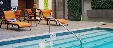 Un espace piscine avec des chaises longues et un escalier pour y accéder.