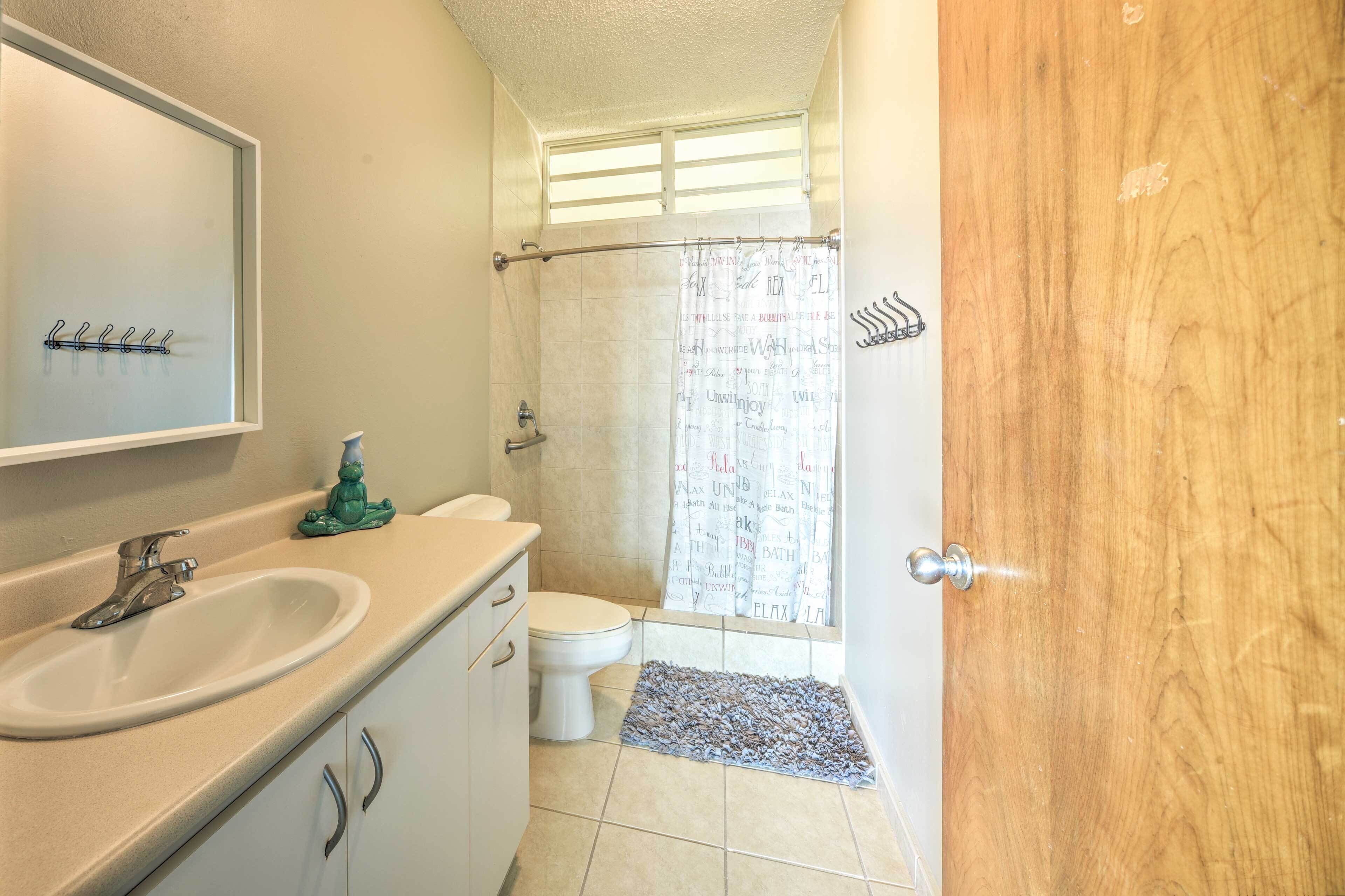 Une salle de bain équipée d’un lavabo, de toilettes et d’un rideau de douche.