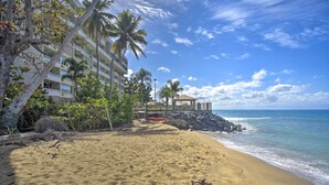 A beach with a building, palm trees, and a gazebo. - Oceanfront Resort Studio - 2 Mi to Rincon Plaza! (Rincon)