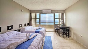 A hotel room with two beds, a desk, and a view of the sea. - Oceanfront Resort Studio - 2 Mi to Rincon Plaza! (Rincon)