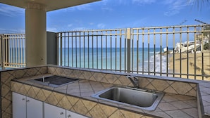 A balcony with a view of the beach and ocean, a sink, and tiled walls. - Oceanfront Resort Studio - 2 Mi to Rincon Plaza! (Rincon)