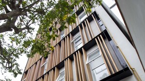 Un hôtel moderne avec une façade en verre et un logo au-dessus de l’entrée.