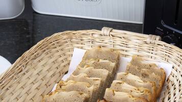 A wicker basket with sliced bread on a kitchen counter.