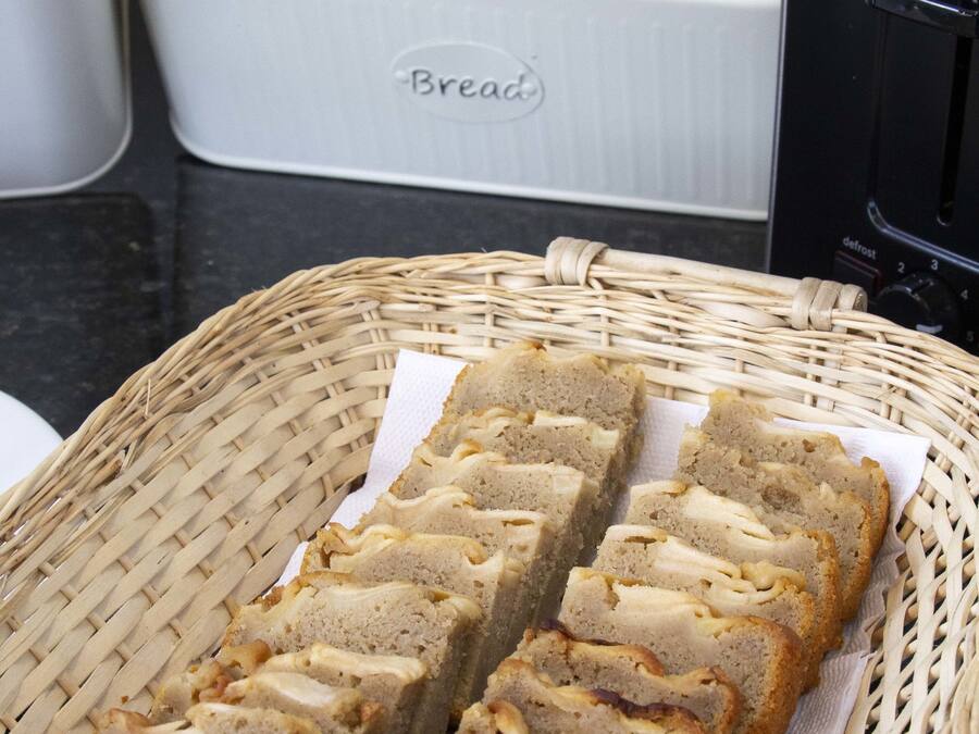 A wicker basket with sliced bread on a kitchen counter.