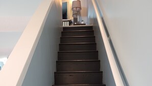 Een trap met donkere houten treden en witte leuningen.