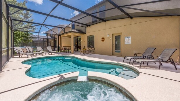 Une piscine extérieure couverte, dotée de chaises longues et d’un jacuzzi.
