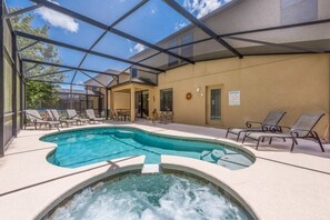 Una piscina al aire libre techada con sillas de descanso y un jacuzzi.