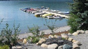 A lakeside dock with boats, surrounded by rocks and vegetation.