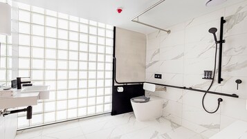 Uma casa de banho moderna com uma janela ampla, um chuveiro e uma sanita.