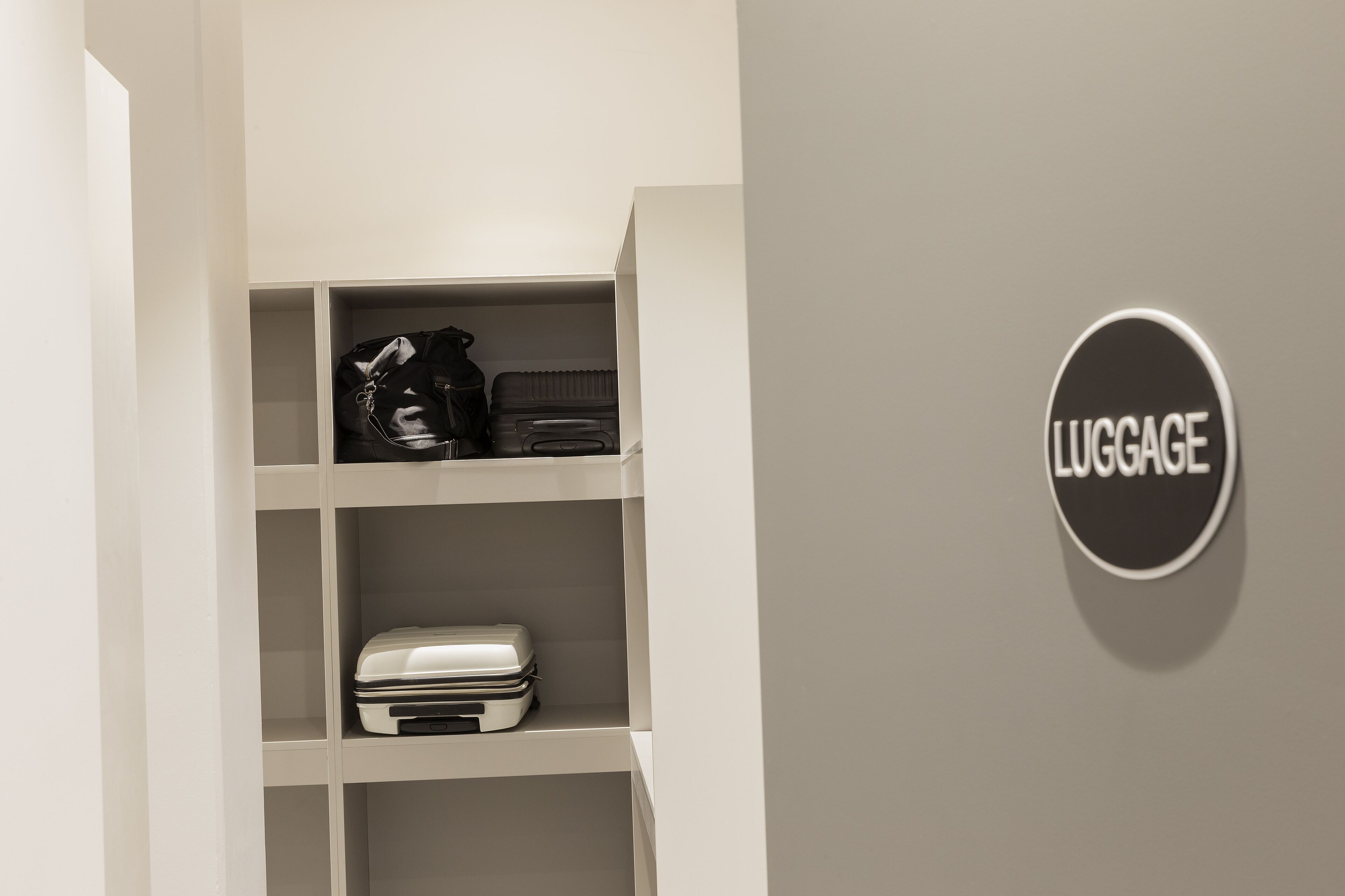 Zona de almacenamiento de equipaje con estantes y un cartel que indica 'LUGGAGE'.