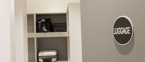 Un espace de stockage pour les bagages, équipé d’étagères et d’un panneau indiquant « BAGAGES ».