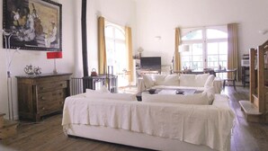 Un salón amplio con un sofá grande, un televisor y un cuadro en la pared.