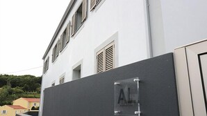Un edificio con fachada blanca, una pared negra y un letrero con las letras "AL".
