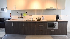 Una cocina moderna con armarios de madera oscura, un lavamanos de acero inoxidable y un horno empotrado.