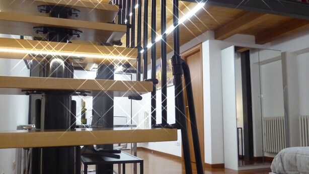 Un interior moderno con una escalera, un comedor y una cama.