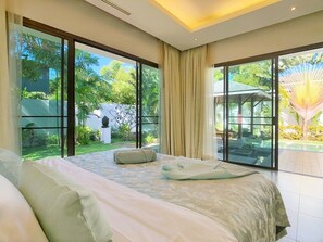 Enjoy expansive views of the lush garden and pool area from the large windows in this stylish room.
