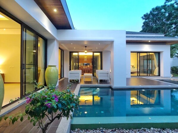 Relax in a spacious outdoor area with a swimming pool and comfortable patio seating.