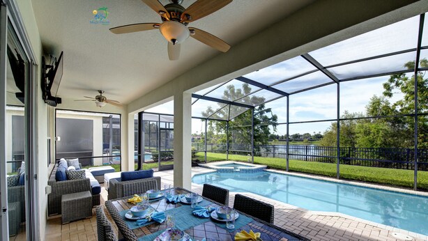 A covered outdoor area with a pool, seating, and a ceiling fan. - Windsor Hills 2nd Premium 5/5 Lake View Home w/South Pool-Near Disney (Kissimmee)