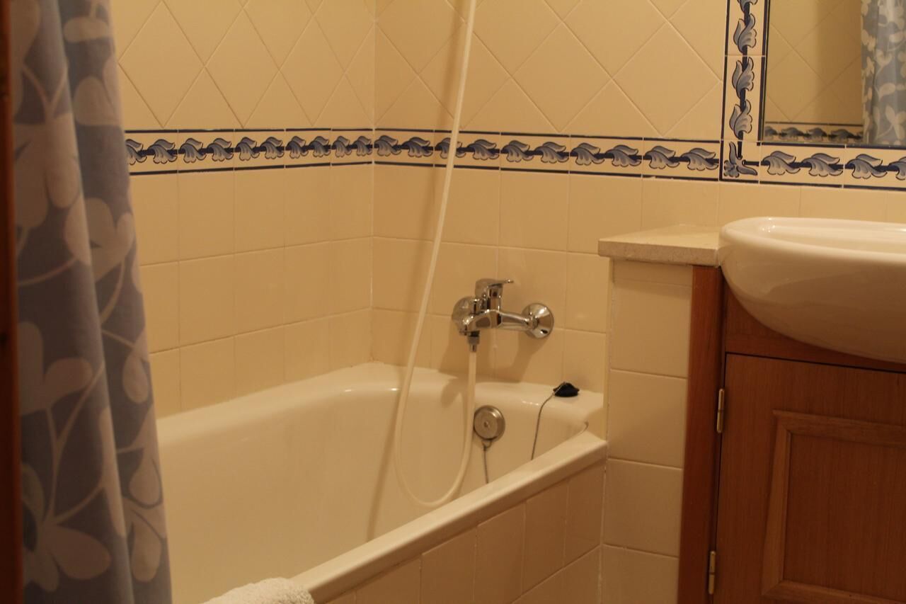 A bathroom with a bathtub, a sink, and a mirror.