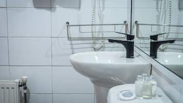 A bathroom with a white sink, a mirror, and a towel rack.