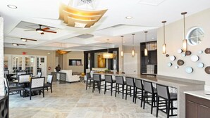 Une cuisine moderne dotée d’un grand îlot central, de sièges de bar et de luminaires suspendus.