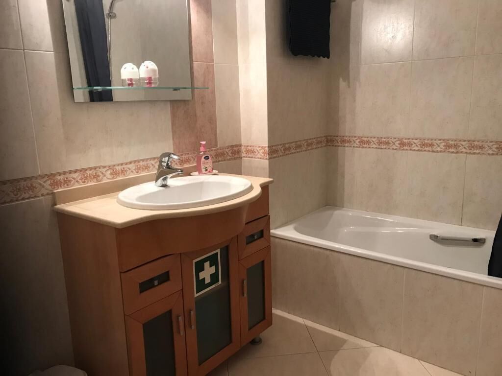 Une salle de bain avec un lavabo, un miroir et une baignoire.
